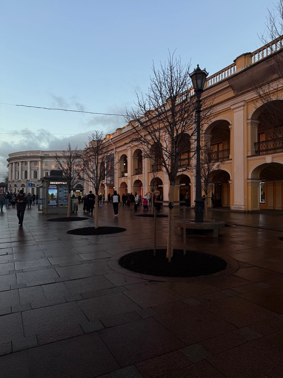 A city street after rain, beside a yellow arcade building