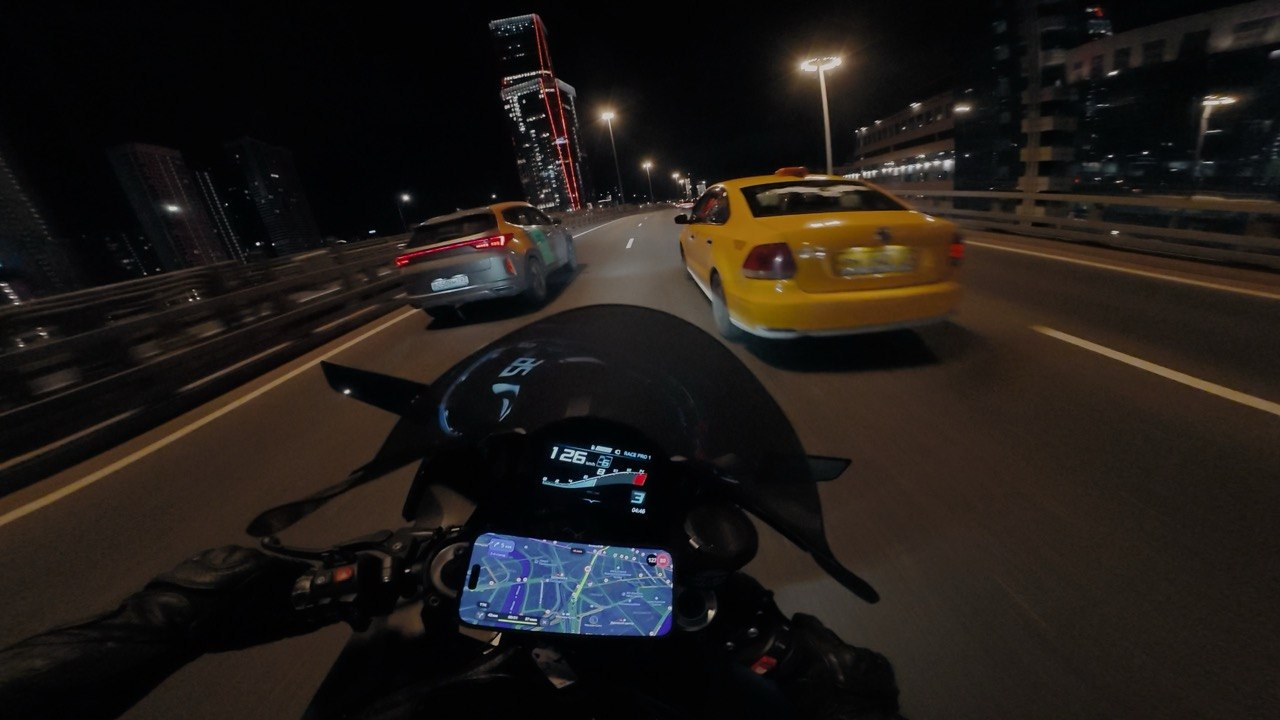 A view from a motorcycle on a city road at night