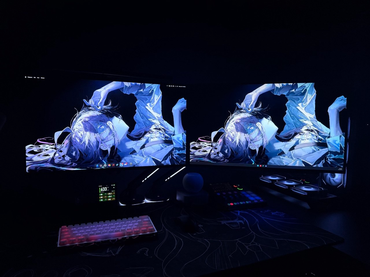 A workspace with two monitors and blue lighting at night